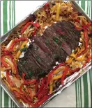  ?? PHOTO BY CATHY THOMAS ?? Roasted peppers and onions surround marinated flank steak for fajitas. All are cooked in the same sheet pan.