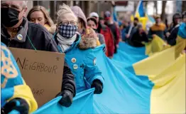  ?? CANADIAN PRESS PHOTO ?? People march with the flag of Ukraine during a rally earlier this month in Saskatoon mourning the deaths of civilians killed during the Russian invasion of Ukraine.