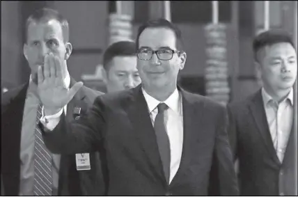  ?? AP PHOTO ?? U.S. Treasury Secretary Steven Mnuchin waves to reporters as he arrives to a hotel after meeting with Chinese officials in Beijing on Thursday.