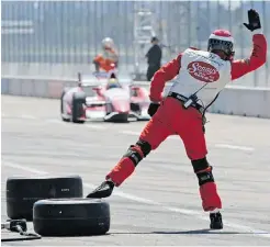  ?? Ed Kaiser, Edmonton
Journal ?? A crew member waves IndyCar driver Justin Wilson into his pit during Sunday’s Edmonton Indy race at the City Centre Airport.