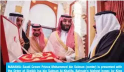  ?? — AFP ?? MANAMA: Saudi Crown Prince Mohammed bin Salman (center) is presented with the Order of Sheikh Isa bin Salman Al-Khalifa, Bahrain’s highest honor, by King Hamad bin Isa Al-Khalifa on Sunday.