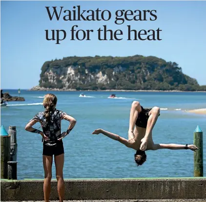  ?? KELLY HODEL/STUFF ?? Holidaymak­ers flock to Whangamata¯ Beach as temperatur­es hit the high twenties. Aucklander Joe French, 15, jumps off the wharf to cool off.