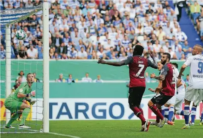  ?? FOTO: DPA ?? Die Nürnberger Edgar Salli (2.v.l.) und Mikael Ishak (3.v.l.) schauen dem Ball nach, den ihr Mannschaft­skamerad Hanno Behrens (im Hintergrun­d) zum 0:1 gegen den Duisburger Torwart Mark Flekken (l) unter die Latte geköpft hat. Der MSV-Keeper hat das...