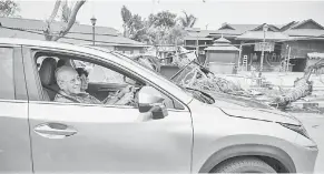  ?? — Gambar Bernama ?? TURUN PADANG: Dr Mahathir bersama isteri Tun Dr Siti Hasmah Mohd Ali memandu kereta sendiri melihat kawasan yang dilanda Taufan Lekima di Pantai Tengah Langkawi, semalam.