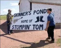  ?? ANDREW VAUGHAN, THE CANADIAN PRESS ?? Workers move a sign at the site of the Stompin Tom Connors cultural centre Wednesday. A part of the new complex, which includes his boyhood home and schoolhous­e, is expected to open briefly next summer.