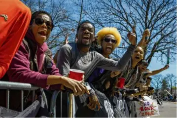  ?? ERIN CLARK/GLOBE STAFF ?? Richard Issa Bockari, center, along with friends, cheered on runners as they reached the top of Heartbreak Hill during the 126th running of the Boston Marathon on April 18, 2022.