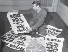  ?? ?? A man with Home Rule posters after nationalis­ts seized the Stone of Destiny; it was returned today in 1951