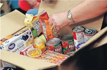  ?? [AP PHOTO] ?? Highland Arts Elementary School teacher Stephanie Uchytil organizes donated food for distributi­on to students and families on the eve of the teacher walk out Wednesday in Mesa, Ariz.