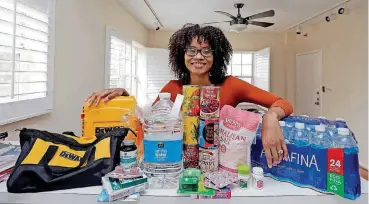  ?? [AP PHOTO] ?? Lexi Montgomery poses with supplies she has purchased in the event of another storm, in Miami Beach, Fla. Hurricane Irma was the first hurricane that Montgomery ever experience­d.