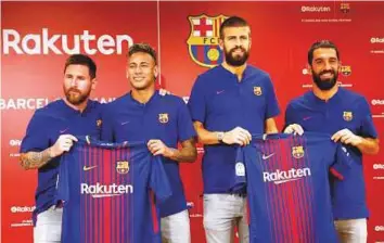  ?? Reuters ?? Lionel Messi (from left), Neymar, Gerard Pique and Arda Turan strike a pose with their FC Barcelona uniforms during a news conference to announce the sponsorshi­p deal between the team and Japanese e-commerce operator Rakuten Inc in Tokyo yesterday.