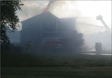  ?? Photos by Joseph B. Nadeau ?? Firefighte­rs battle a house fire at 10 Pine Acres Road in Bellingham on Friday.