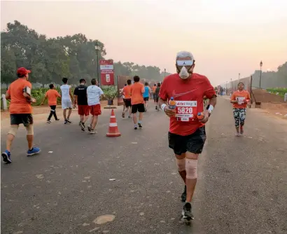  ?? PTI ?? A runner wearing a mask takes part in the Airtel delhi Half marathon 2018 at rajpath in new delhi on Sunday. —