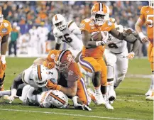  ?? BOB LEVERONE/THE ASSOCIATED PRESS ?? Clemson’s Tavien Feaster, front, runs for a touchdown against Miami during the Atlantic Coast Conference championsh­ip Dec. 2 in Charlotte, N.C. Clemson faces Alabama on Jan. 1 in the Sugar Bowl.