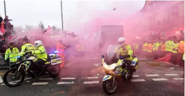  ?? — AFP photo ?? Bottles and cans are thrown at the bus as Manchester City players arrive at the stadium before the UEFA Champions League first leg quarter-final between Liverpool and Manchester City, at Anfield stadium in Liverpool, north west England.