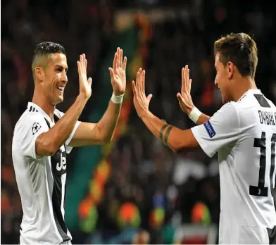  ?? Zimbio ?? Paulo Dybala of Juventus celebrates with teammate Cristiano Ronaldo after scoring during the Champions League match against Manchester United at Old Trafford on October 23, 2018 .Photo: