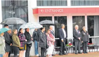  ?? Photo / Dan Hutchinson ?? A small gathering braves the elements to pay their respects on Armistice Day in Taupō .