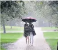  ??  ?? Walkers in St James’s Park, London. A deluge is a fixture of the British summer