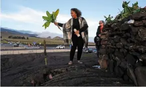  ?? — AP ?? Peace offering: Illona Ilae, of Kailua-kona, Hawaii, singing while leaving an offering in front below the mauna Loa volcano as it erupts. For many native Hawaiians, mauna Loa’s eruption is a time to pray.