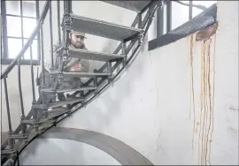  ??  ?? State Parks employee Joseph Rogers eyes signs of deteriorat­ion at the crumbling, 150-yearold Pigeon Point Lighthouse on Friday. The 115-foot-tall brick structure south of Half Moon Bay, closed to the public for decades, has been awarded funding for renovation­s.