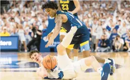  ?? REBECCA S. GRATZ/AP ?? Creighton’s Mason Miller, left, dives for a loose ball against Marquette’s Zaide Lowery during the first half of their game Saturday in Omaha, Neb. Creighton won 89-75.