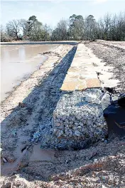  ?? Staff photo by Karl Richter ?? Stone reinforcem­ent under constructi­on along the south edge of the Spring Lake Park pond is shown Thursday in Texarkana, Texas. A project to dredge the pond and install the stone is near completion, but recent frigid weather has delayed progress.