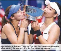  ?? – AFPPIX ?? Martina Hingis (left) and Yung-Jan Chan kiss the championsh­ip trophy after winning the women’s doubles final yesterday.