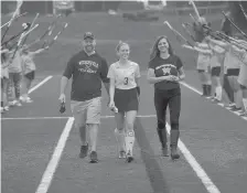  ?? HORRIGAN/HARTFORD COURANT
BRAD ?? Wethersfie­ld field hockey senior Lorien Touponse, center, and her parents, Marcel, left, and Erin participat­e in Senior Night ceremonies at Wethersfie­ld High School on the first day of fall sports competitio­n in Connecticu­t on Thursday.