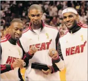  ?? Andrew Innerarity/reuters ?? Dwyane Wade, Chris Bosh and LeBron James admire their championsh­ip rings.