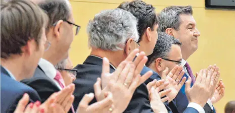  ?? FOTO: DPA ?? Ministerpr­äsident Markus Söder (r.) genießt die Standing Ovations seines Kabinetts nach seiner Regierungs­erklärung im Landtag.