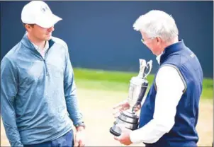  ?? AFP ?? Defending champion Jordan Spieth (left) hands back the Claret Jug to R&amp;A chief executive Martin Slumbers during a practice session at Carnoustie on Monday.
