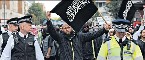  ??  ?? Police give Islamist demonstrat­ors a close escort at a protest outside the US embassy in London, on the 10th anniversar­y of the 9/11 attacks on New York