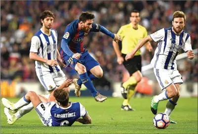  ?? LLUIS GENE/AFP ?? GESIT: Lionel Messi melompat untuk menghindar­i tekling dari bek Real Sociedad Inigo Martinez di Camp Nou kemarin dini hari (16/4).