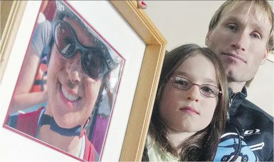  ?? TED RHODES/ CALGARY HERALD/ FILES ?? Heath McCroy and his daughter Lea with a picture of his wife, and her mom, Isabelle Dube, who died after a bear attack in 2005.