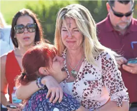  ?? JOEL AUERBACH/AP ?? Parents wait for news after reports of the shooting at Marjory Stoneman Douglas High School in Parkland, Fla., last Feb. 14.