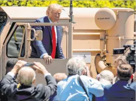  ?? Andrew Harnik The Associated Press ?? President Donald Trump gets out of the driver’s seat of Lockeed Martin’s Terminal High Altitude Area Defense (THAAD) anti-ballistic missile defense system Monday during a Made in America showcase on the South Lawn of the White House.