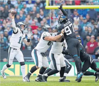  ??  ?? Eagles quarterbac­k Carson Wentz, left, throws a pass against the Jaguars.