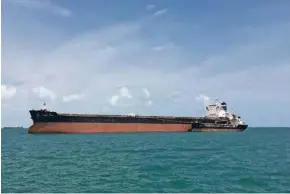  ?? (ROSLAN KHASAWNEH/ REUTERS) ?? Un «capesize», capable de transporte­r plus de 200 000 tonnes de charbon, sillonne les eaux au large de Singapour. SwissMarin­e gère des bateaux de ce type.