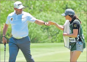  ??  ?? Lee Westwood celebrates a birdie with his girlfriend and caddie, Helen Storey, on the ninth yesterday