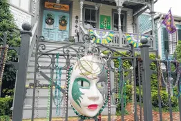  ??  ?? Susan Alexander-Clarke and Robert Clarke deck out their Sealy Avenue home with traditiona­l Mardi Gras decoration­s.