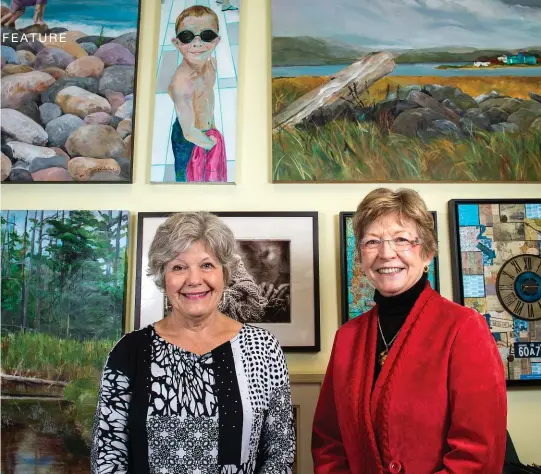  ??  ?? Anne Williamson, left, president of the Kitchener-Waterloo Society of Artists, and Arlene McCarthy, vice-president, pose in front of various artworks by society members at Frames by Verne in Kitchener.