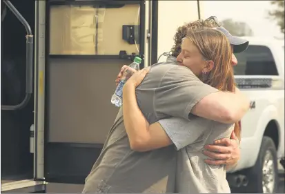  ?? PHOTOS BY CARIN DORGHALLI — ENTERPRISE-RECORD ?? Katherine Molohon hugs James “Woody” Faircloth to thank him for setting her up with a recreation­al vehicle on Saturday in Oroville. Molohon is a volunteer firefighte­r in Berry Creek. She lost her home in the North Complex fire.