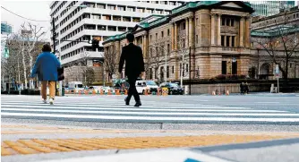  ?? Reuters-Yonhap ?? People walk in front of the Bank of Japan building in Tokyo, Jan. 23.