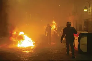  ?? Foto: Kamil Zhinioglu, dpa ?? Polizisten suchen in den Straßen von Paris nach gewaltbere­iten Gruppen der „Gelbwesten“-Bewegung, die immer wieder Straßenspe­rren und Fahrzeuge anzündeten.