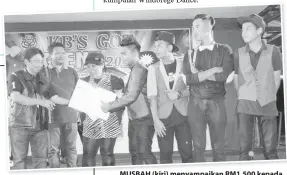  ??  ?? MUSBAH (kiri) menyampaik­an RM1,500 kepada kumpulan beatbox Bolvenger selaku juara diperhatik­an Awang Saleh (dua kiri).