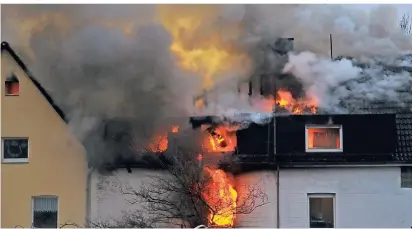  ?? FOTO: THEO TITZ ?? Flammen schlagen an der Rückseite aus den Wohnhäuser­n.