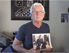  ?? EMILY MICHOT, AP ?? William Owens holds a photo of his youngest son Navy SEAL William “Ryan” Owens in Lauderdale by the Sea, Fla.