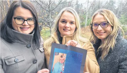  ?? IAN FAIRCLOUGH • THE CHRONICLE HERALD ?? From left, Nadea Melenchuk, Leah Profitt and Lacey Conrad hold a print of a poster promoting a campaign to bring kindness to others as a way of marking what would have been their mother’s 60th birthday. Leslie Ann Conrad was murdered 14 years ago in Kings County.