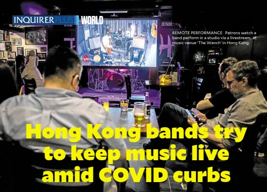  ?? ?? REMOTE PERFORMANC­E Patrons watch a band perform in a studio via a livestream, at music venue ‘The Wanch’ in Hong Kong.