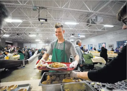  ??  ?? TOP: Luther Wyatt, formerly of California, bows in prayer before having his Thanksgivi­ng meal Thursday at Catholic Charities of Southern Nevada.