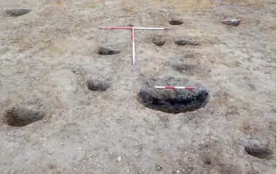  ??  ?? Above: Postholes and a hearth pit in the roundhouse (near scale 20cm)